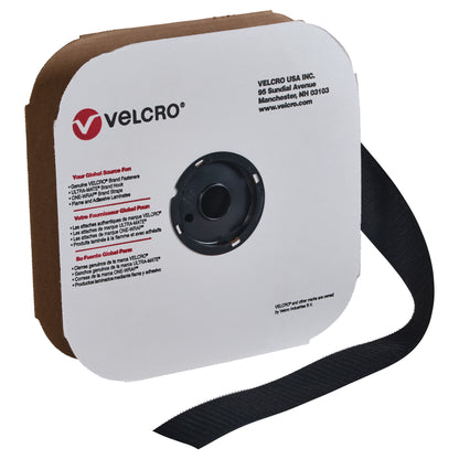 Roll of Standard VELCRO Brand Hook Tape partially unrolled from a white and brown dispenser with printed text.