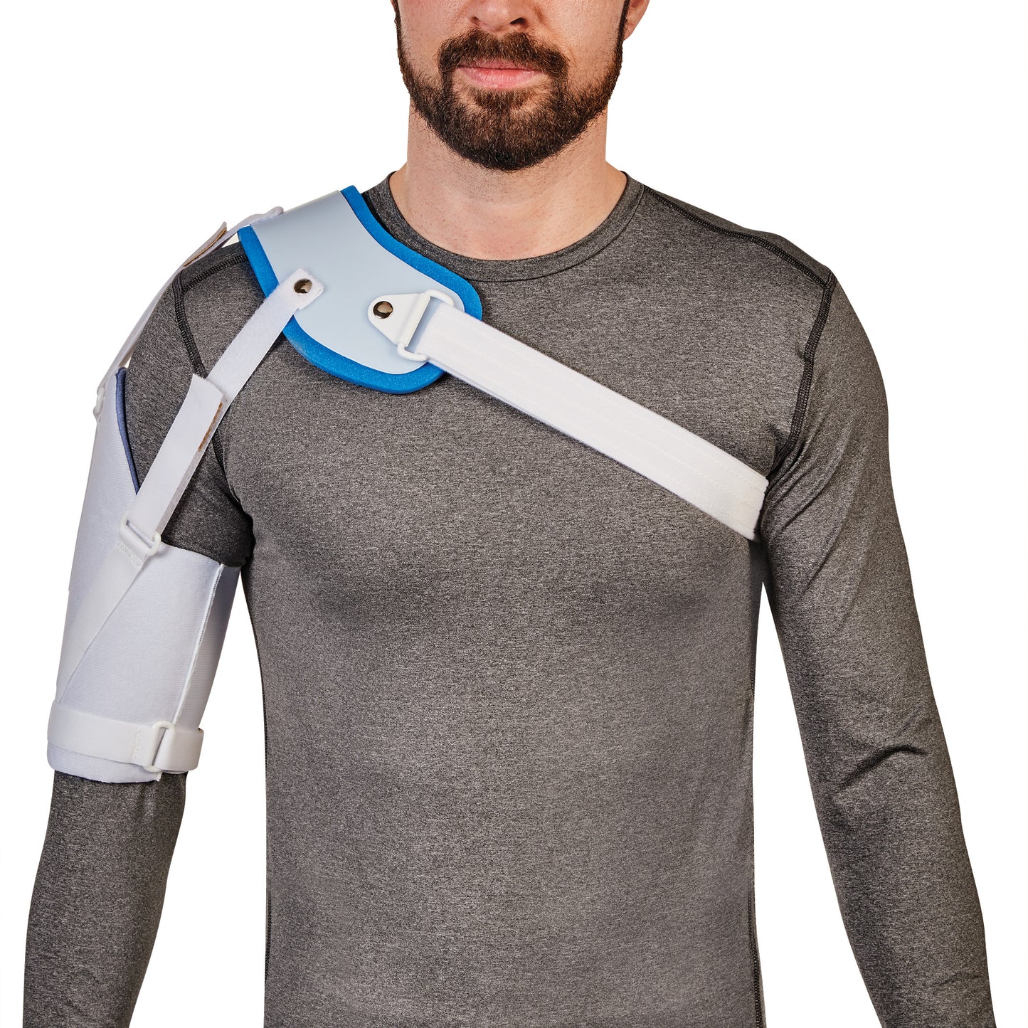 A man wears an AliMed Hemi-Shoulder Sling over a gray shirt, featuring white straps and blue padding for shoulder support.
