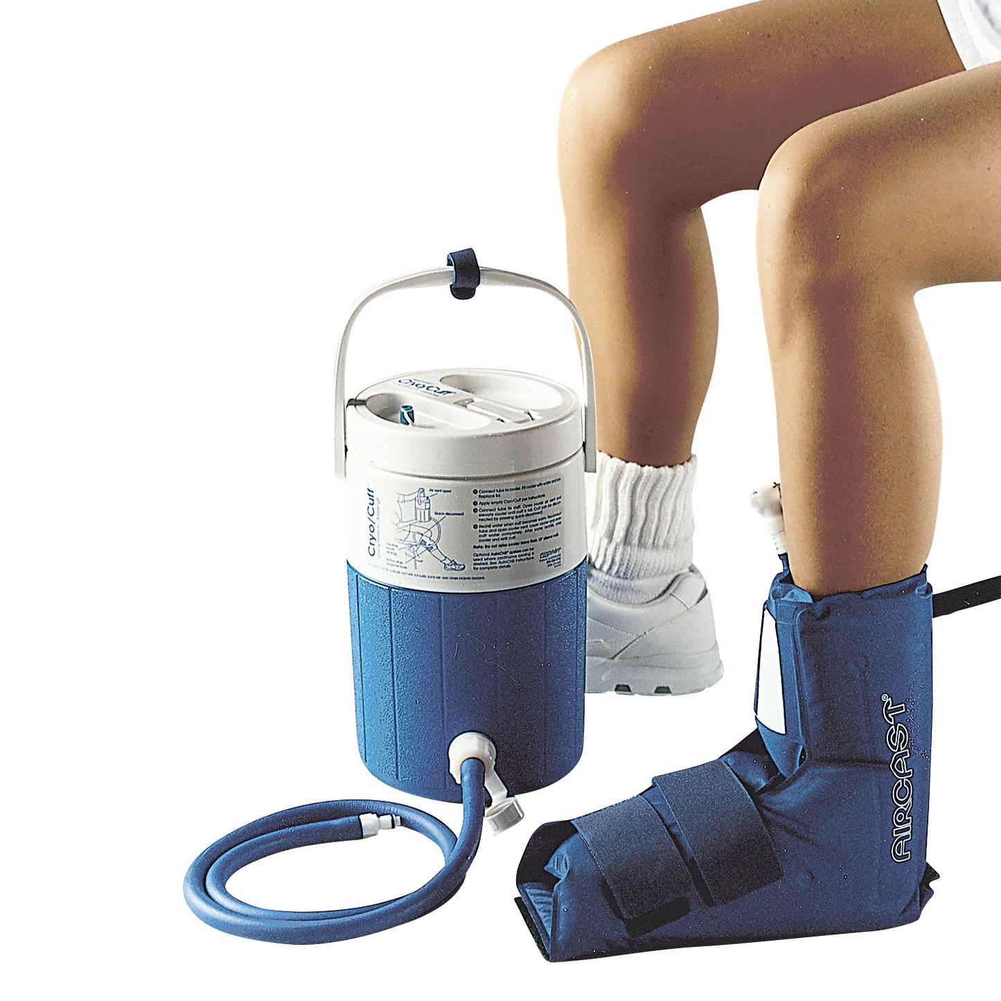 Person with a blue Aircast Cryo/Cuff System on their leg, showing a cooler and hose connected to provide ice therapy.