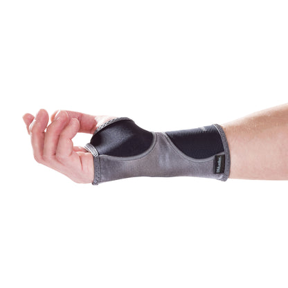 A hand wears a Mueller Hg80 Wrist Support, a gray and black brace providing support around the wrist and thumb area.