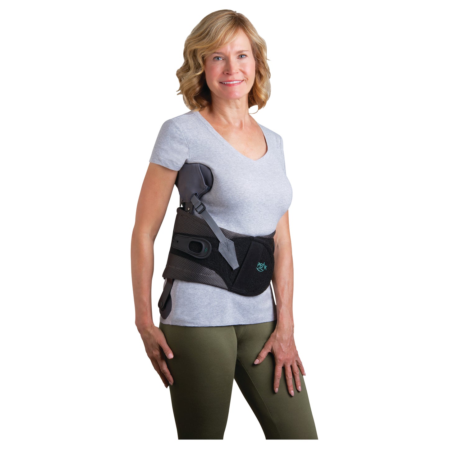 A woman wearing the Peak Scoliosis Bracing System. The brace is black and supports the torso, worn over a gray shirt.