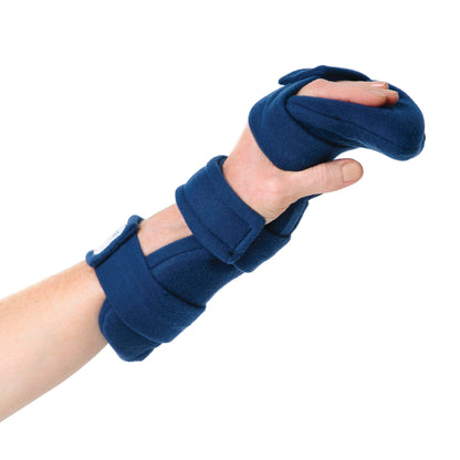 A hand wearing the Comfy Splints Pediatric Hand/Thumb Orthosis, a blue padded brace with straps, supporting the wrist and thumb.