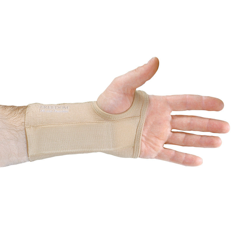 A hand wearing the AliMed FREEDOM Short Elastic Wrist Support, showcasing its beige color and snug fit around the wrist.