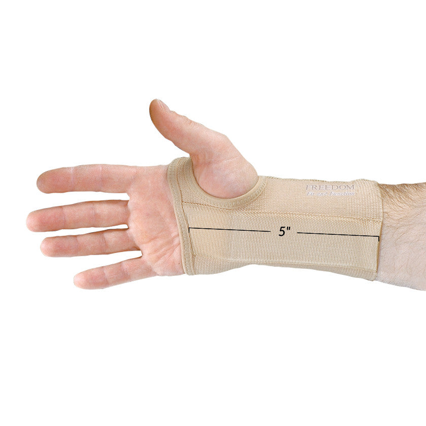 A beige AliMed FREEDOM Short Elastic Wrist Support is worn on a hand with fingers extended, measuring 5 inches in length.