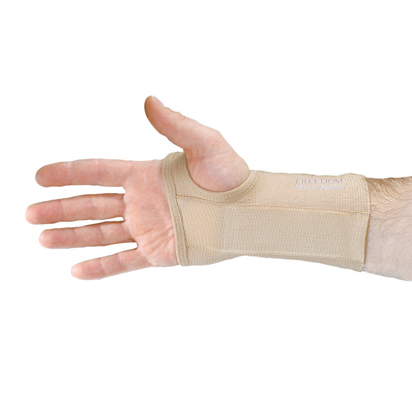 A hand wearing the AliMed FREEDOM Short Elastic Wrist Support. The beige support covers the wrist and part of the hand.