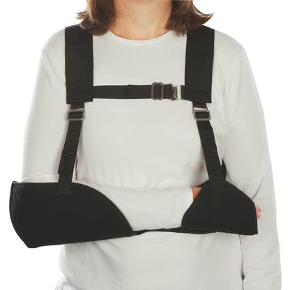 A person wearing a Harris Hemi-Arm Sling, supporting the arm with black straps and cushioned armrest over a white shirt.