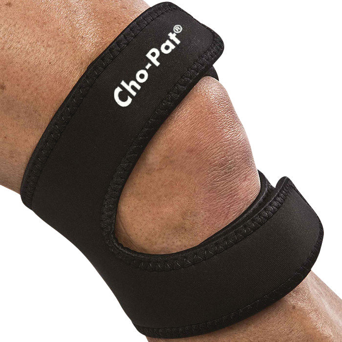 A close-up of a knee wearing the Cho-Pat Dual-Action Knee Strap, providing support with two black straps.