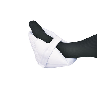 Foot in a SkiL-Care Ultrasoft Heel Cushion with black socks. The white cushion wraps around the heel for comfort and protection.