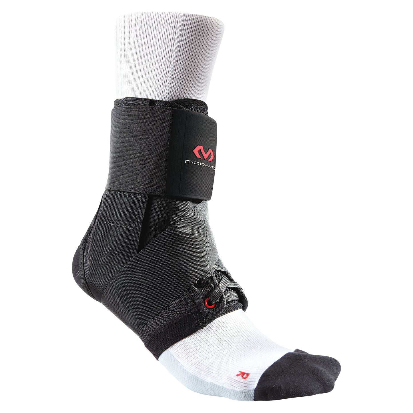 A foot wearing a white sock and a McDavid Ultralight Ankle Brace, featuring black straps and a red logo on the side.