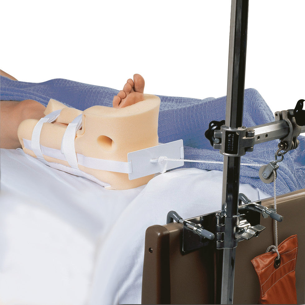 A foot is secured in a HEELIFT Traction Boot with straps, attached to a traction device on a hospital bed.