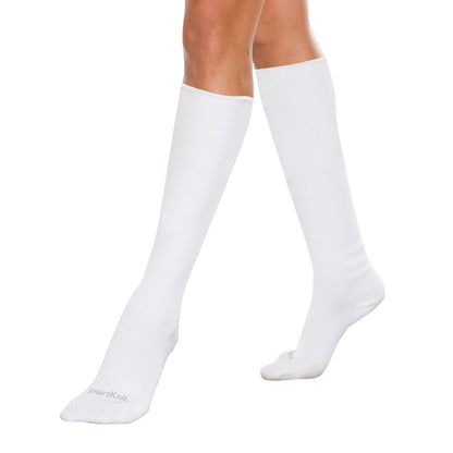 A person wearing white SmartKnit Seamless Over-the-Calf Socks, showcasing their length and snug fit.