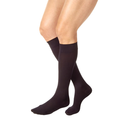 Person wearing Jobst Relief Knee-High Compression Stockings in black, showing knees down to feet against a white background.