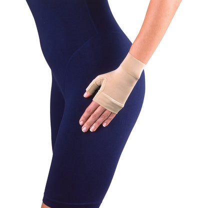 A person wearing a Jobst Bella Lite Gauntlet, a beige compression glove, over a dark blue outfit, with their hand on their hip.