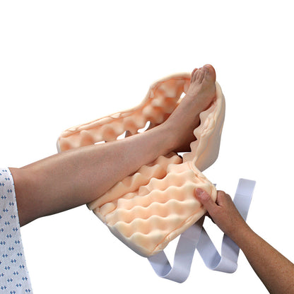A leg is being placed into a HEELIFT Suspension Boot. The boot is peach-colored with a textured, cushioned interior.