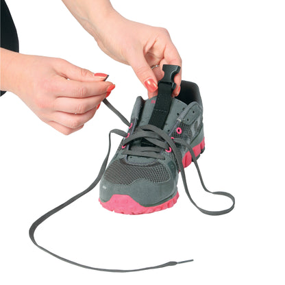 A person adjusts the AliMed FREEDOM Adjustable Footdrop Brace on a gray and pink athletic shoe using black laces.