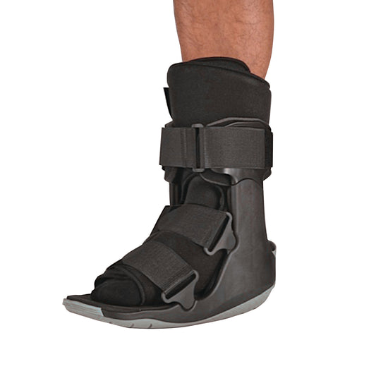 A person wearing the Ovation Medical Gen2 Short Non-Pneumatic Walker Boot, designed with adjustable straps and a durable sole.