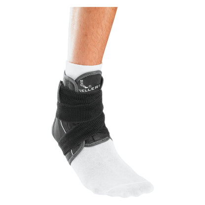 Person wearing a Mueller Hg80 Ankle Brace with Straps over a white sock, providing support and stability to the ankle.