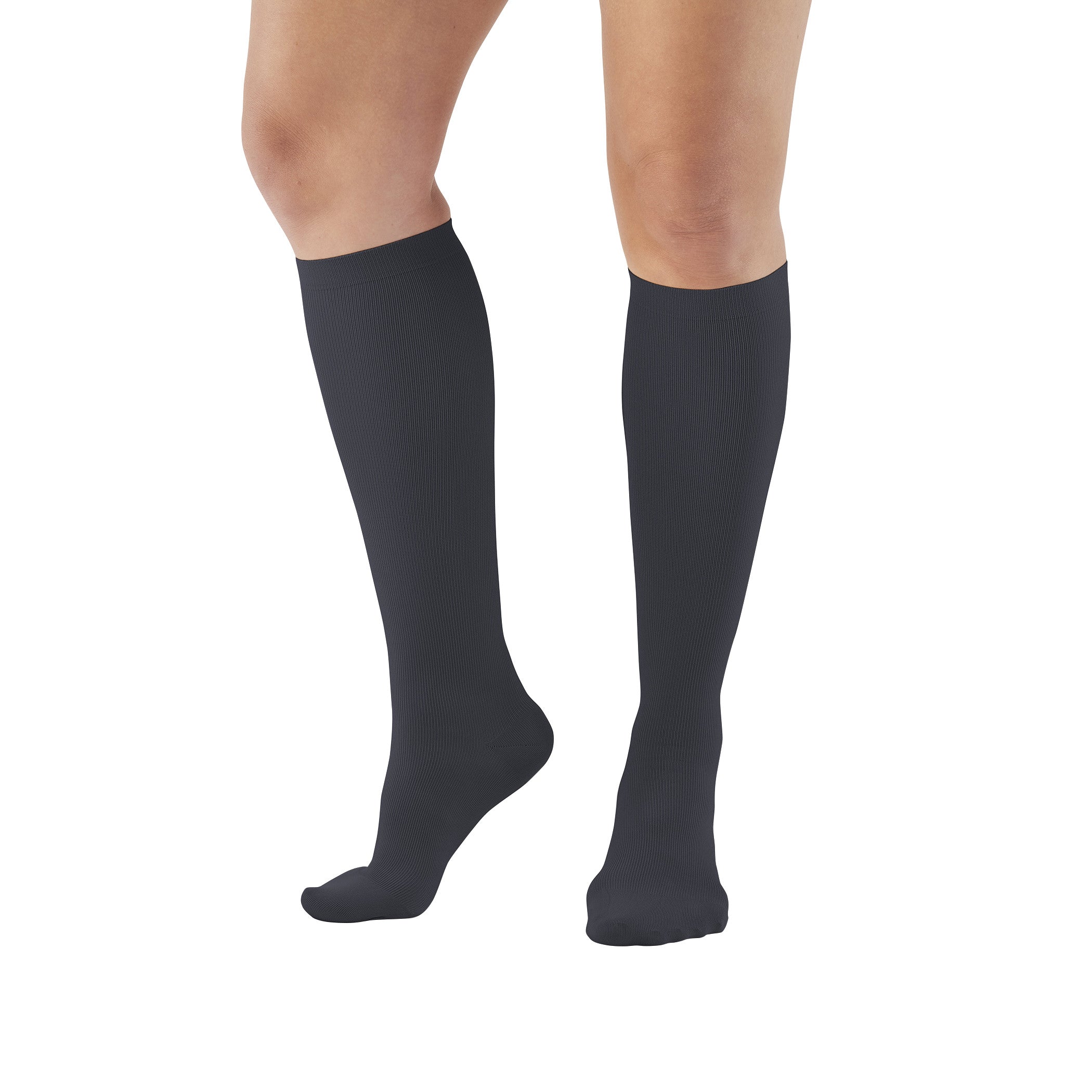 A person wears Ames Walker Knee-Length Microfiber Support Socks in black, covering calves, on a white background.