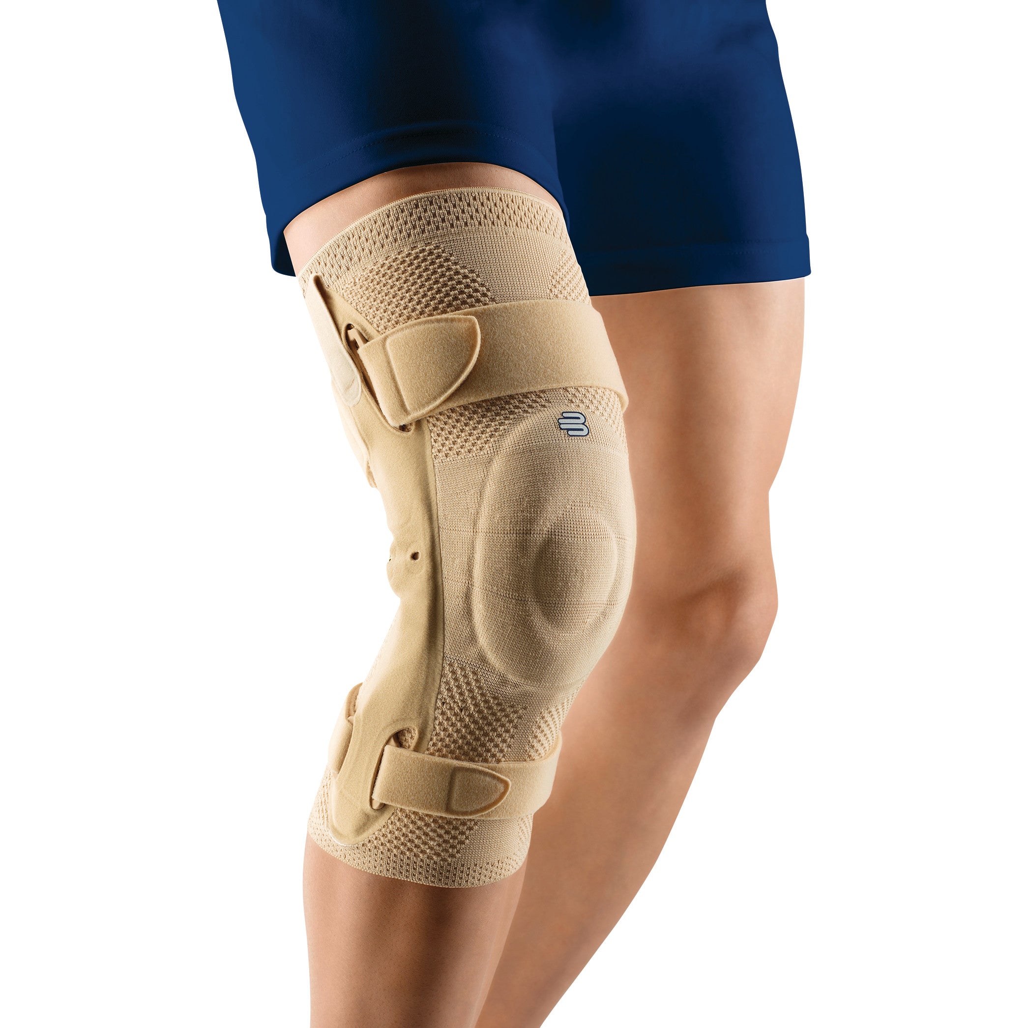A person wears a Bauerfeind GenuTrain S Knee Brace on their right knee. The brace is beige with adjustable straps.