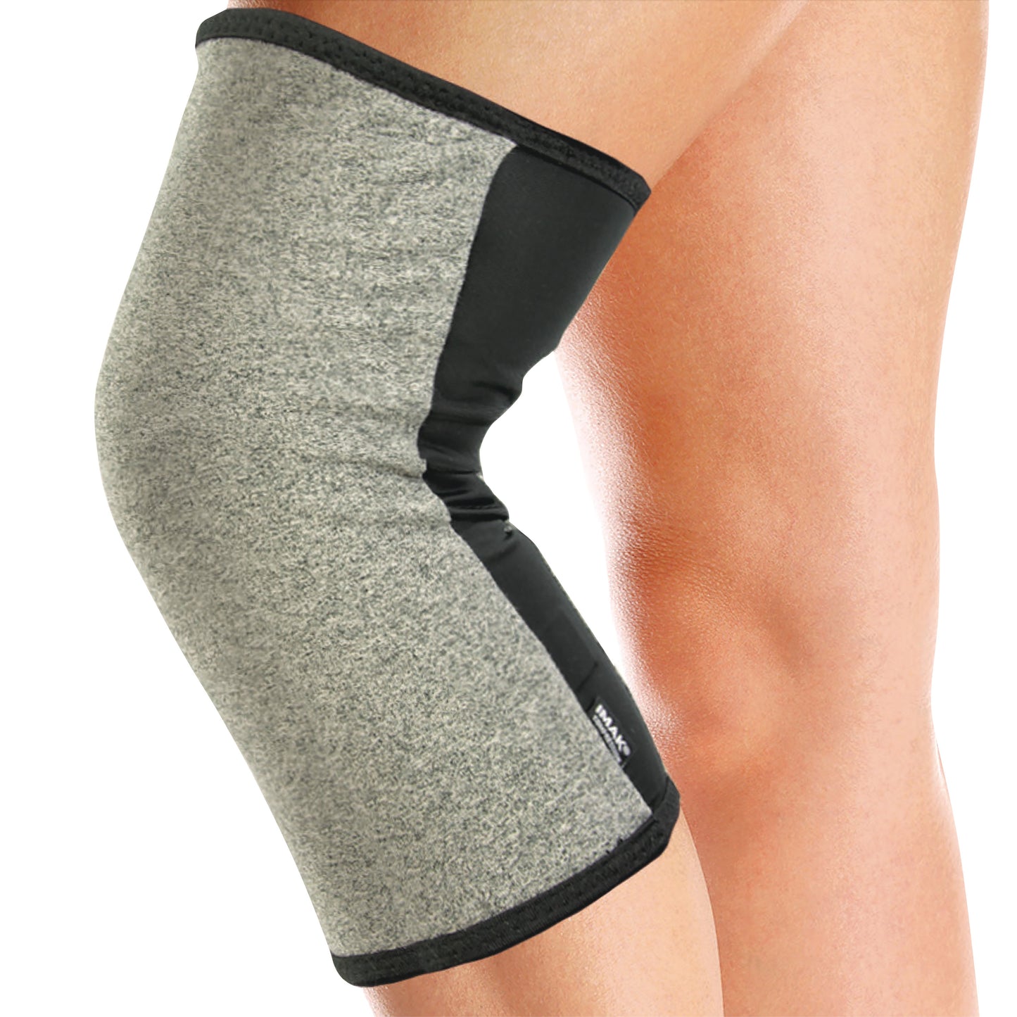 A person wears a Brownmed IMAK Compression Arthritis Knee Sleeve. It's gray with black edges, covering the knee joint.