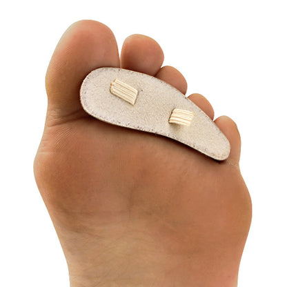 A foot wearing a Silipos Hammer Toe Crest, a soft pad designed to relieve pressure and support the toes, viewed from the sole.