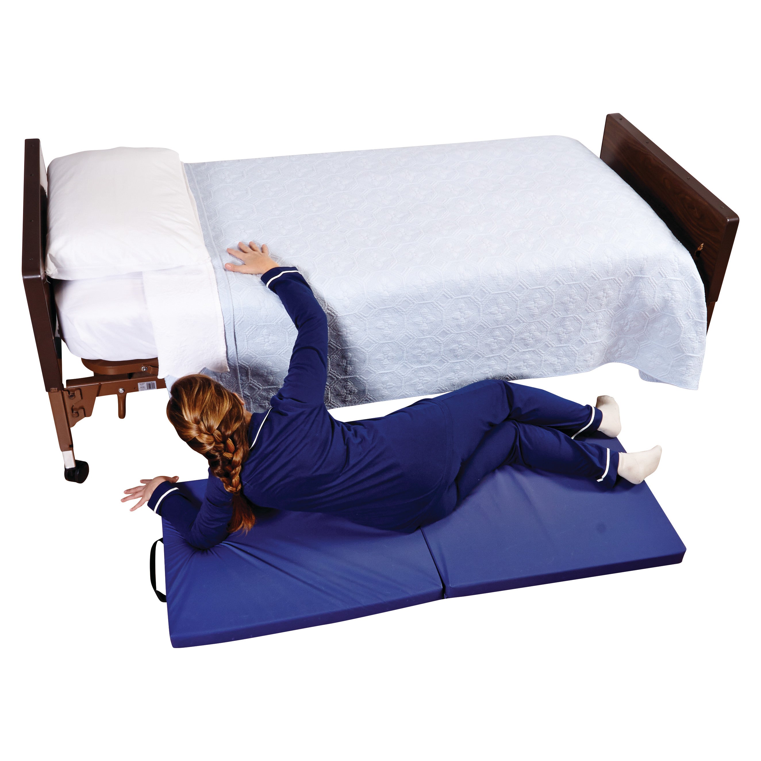 A person lies on the AliMed Economy Bi-Fold Bedside Fall Mat with Handles, placed next to a bed with a light blue cover.