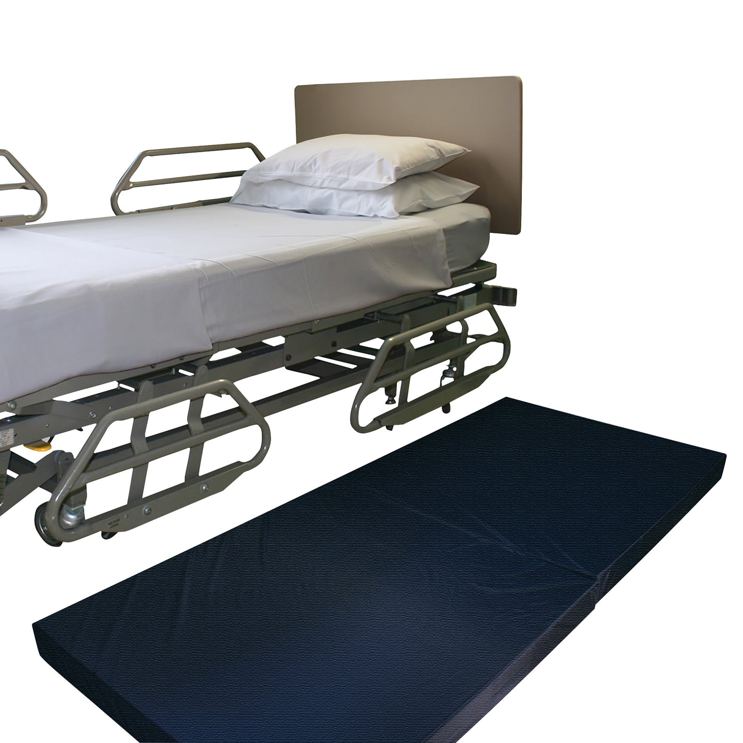 A hospital bed with rails and white bedding next to a black NYOrtho Bedside Safety Mat on the floor.