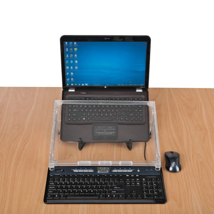 A Microdesk Compact Writing Platform sits on a wooden desk between a laptop and a keyboard, with a mouse beside it.