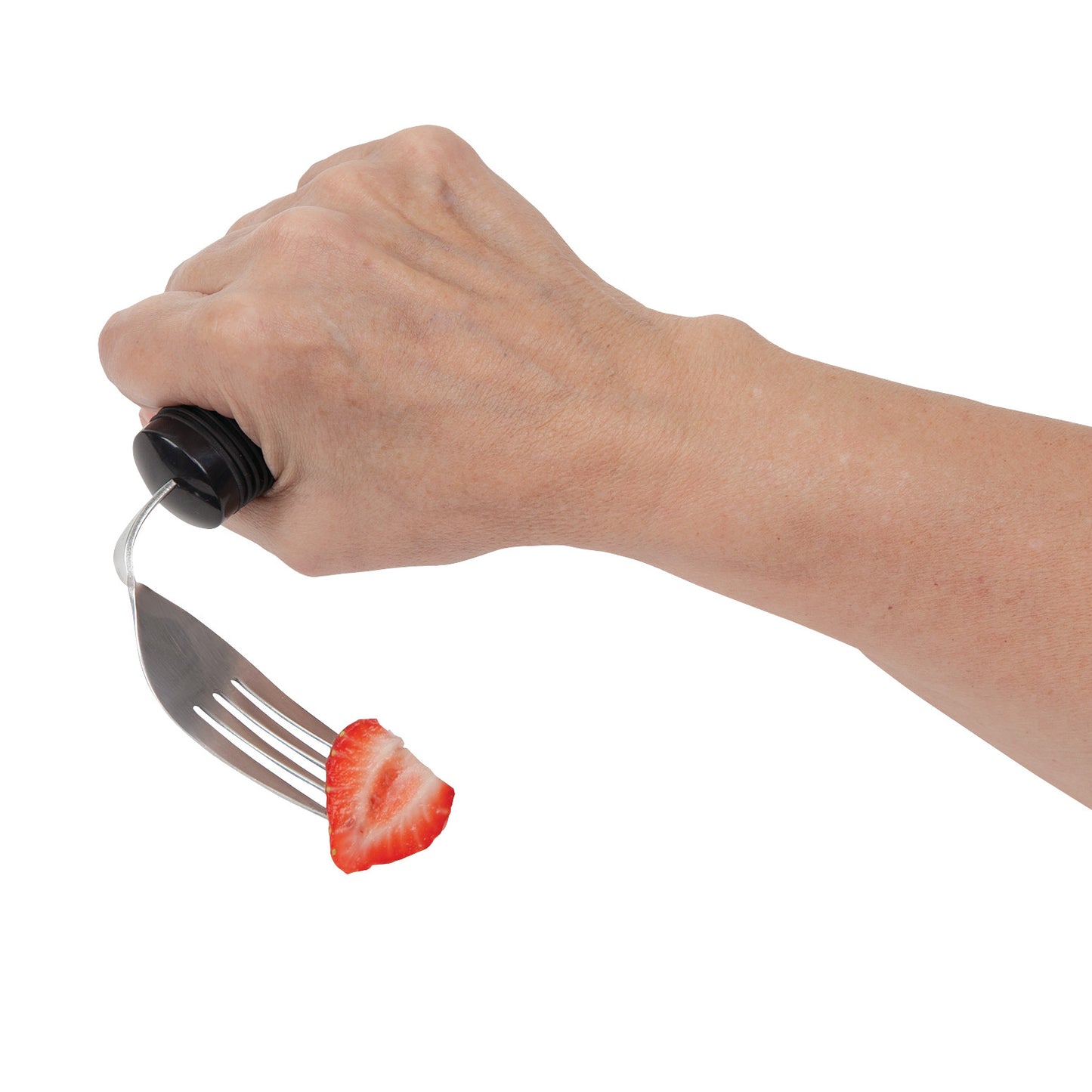 A hand holds a Good Grips Weighted Utensil fork with a sliced strawberry on it, against a white background.
