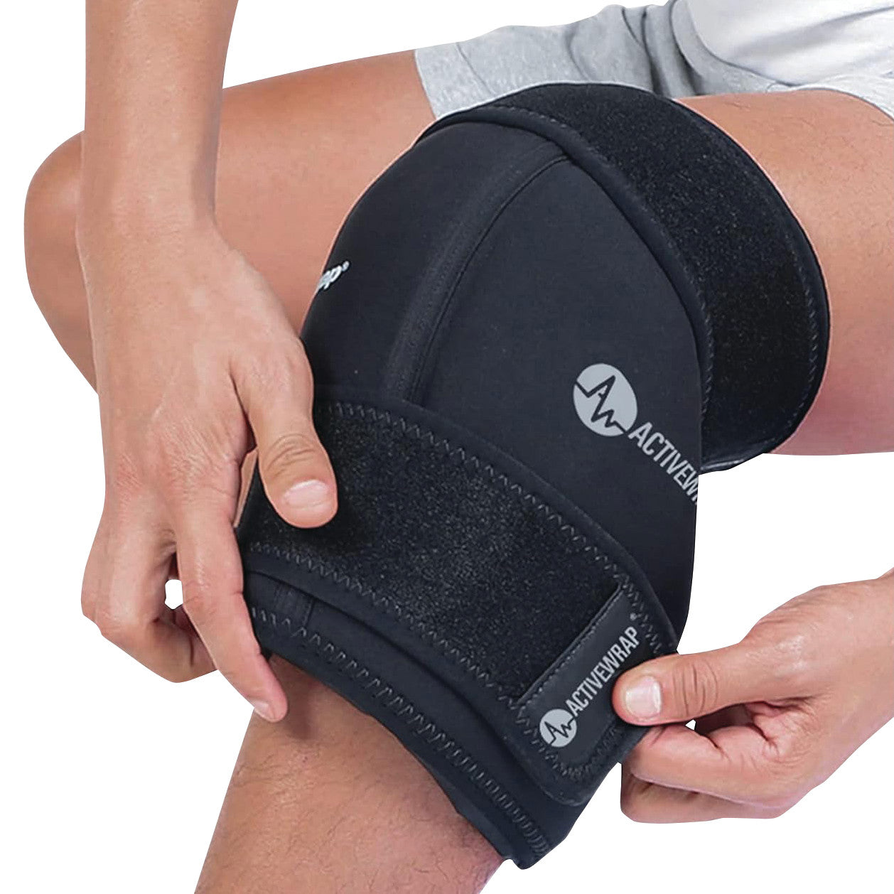 A person adjusts an "ActiveWrap" knee brace. It is black with straps and features the ActiveWrap logo.