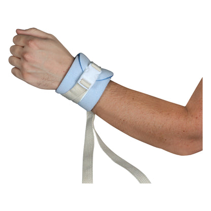 A person's wrist is secured with a Posey Limb Holder featuring a blue fabric cuff and a white quick-release buckle.