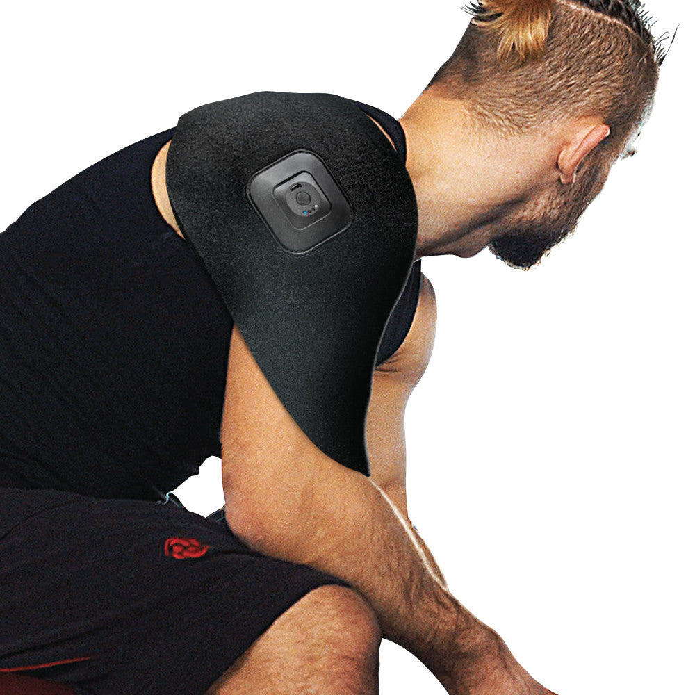A person wears the Intellinetix Universal Therapy Wrap on their shoulder, featuring a square vibration unit on a black sleeve.
