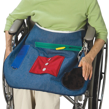 A person in a wheelchair wears a Posey Activity Apron with buttons, zippers, and pockets on it.