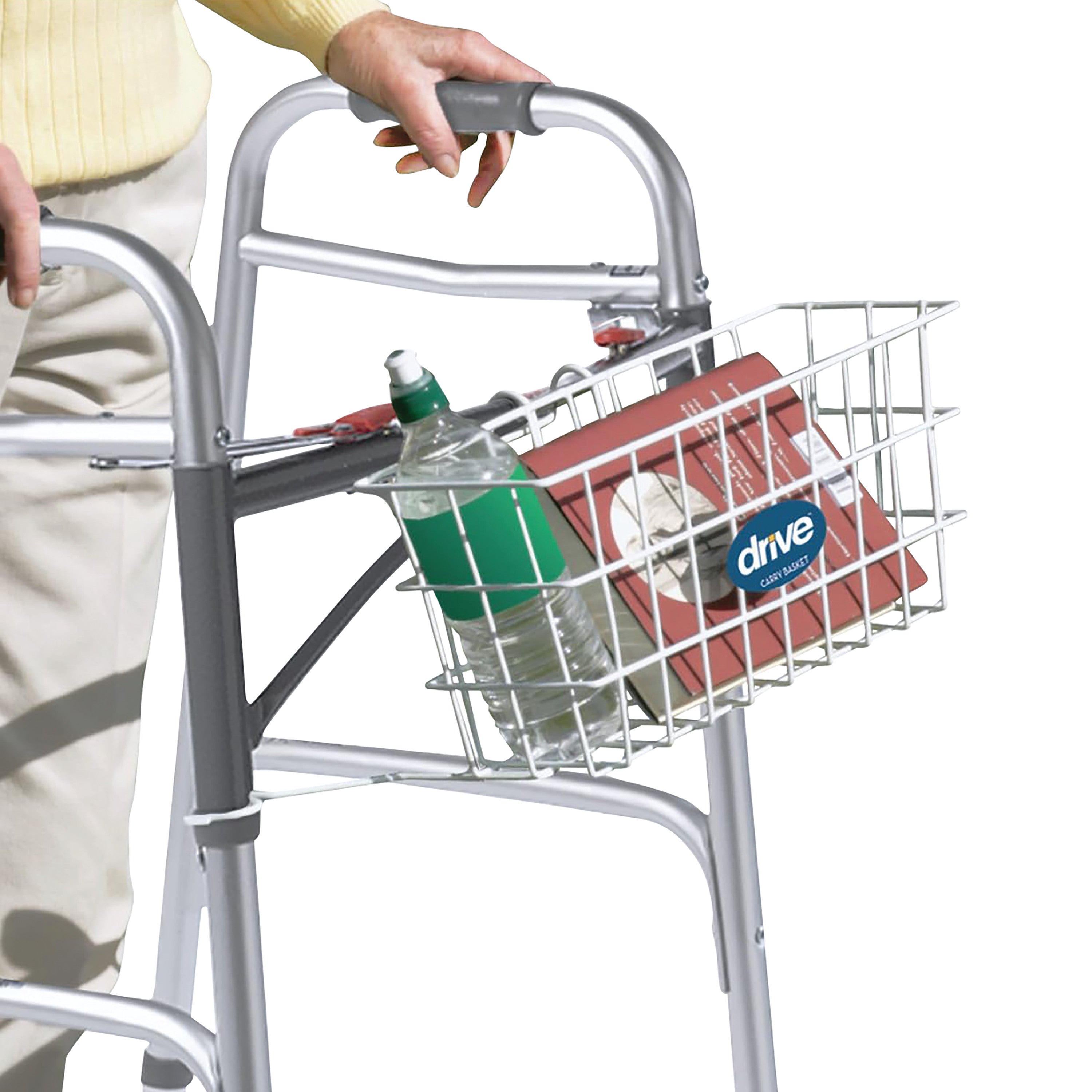 A person uses a Drive Medical Deluxe Folding Walker with an attached basket holding a green bottle and a red box.