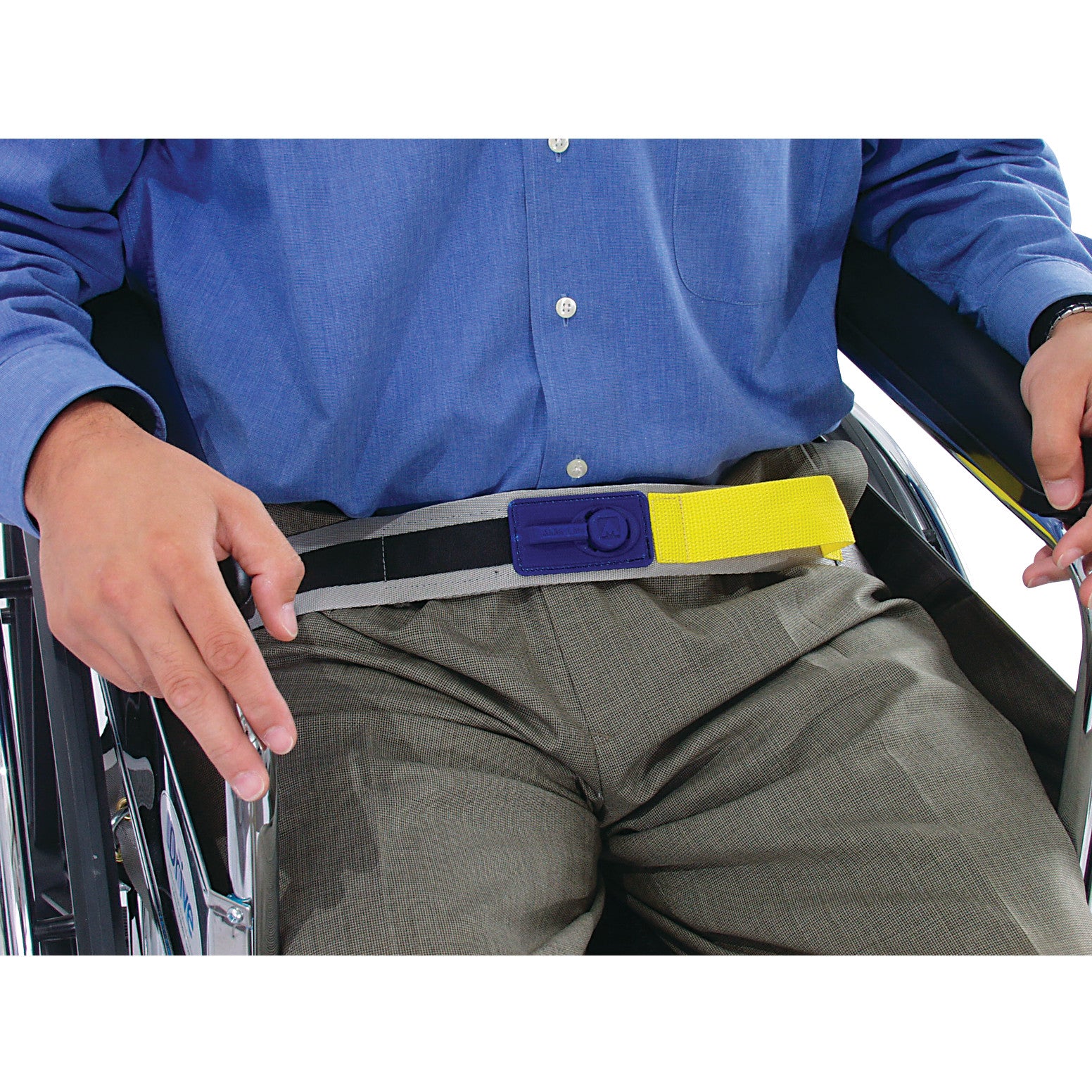 A person in a wheelchair wears the AliMed E-Z Release Seatbelt with Basic Alarm. The belt is yellow and black with a blue buckle.