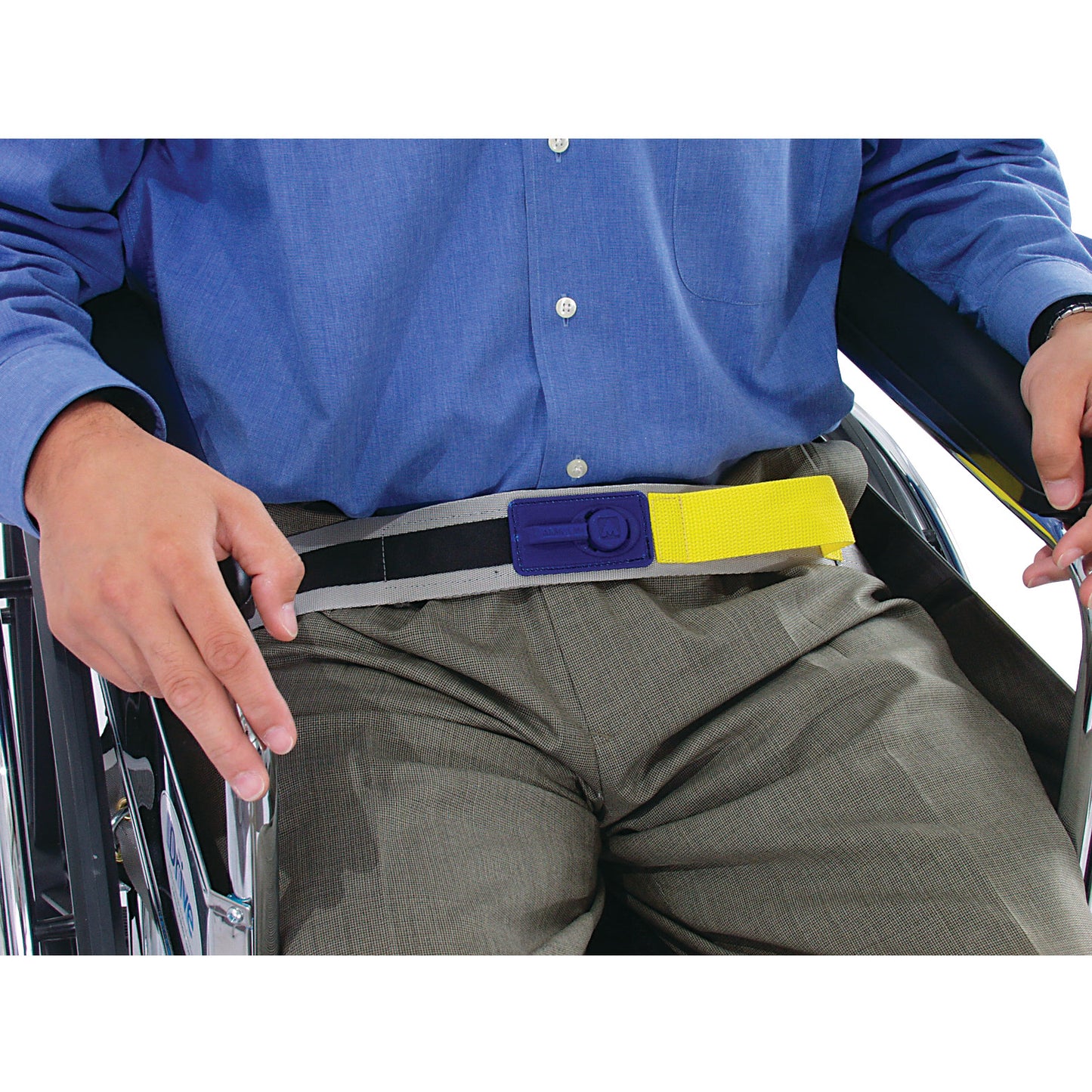 A person in a wheelchair wears the AliMed E-Z Release Seatbelt with Basic Alarm. The belt is yellow and black with a blue buckle.