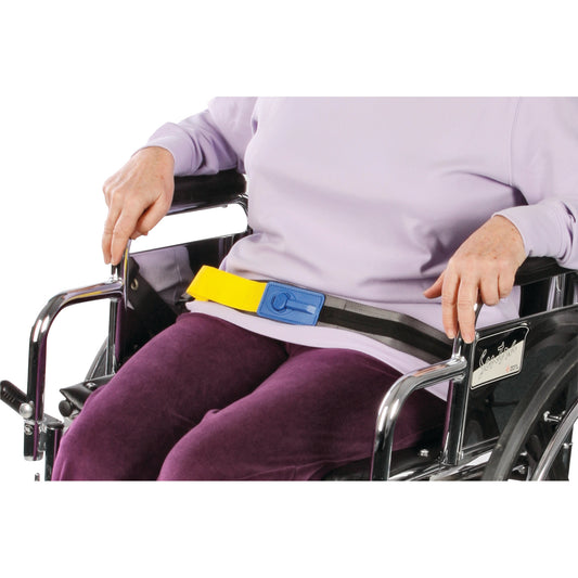 A person in a wheelchair wears an AliMed Early Warning E-Z Release Seatbelt with a yellow strap and blue buckle.
