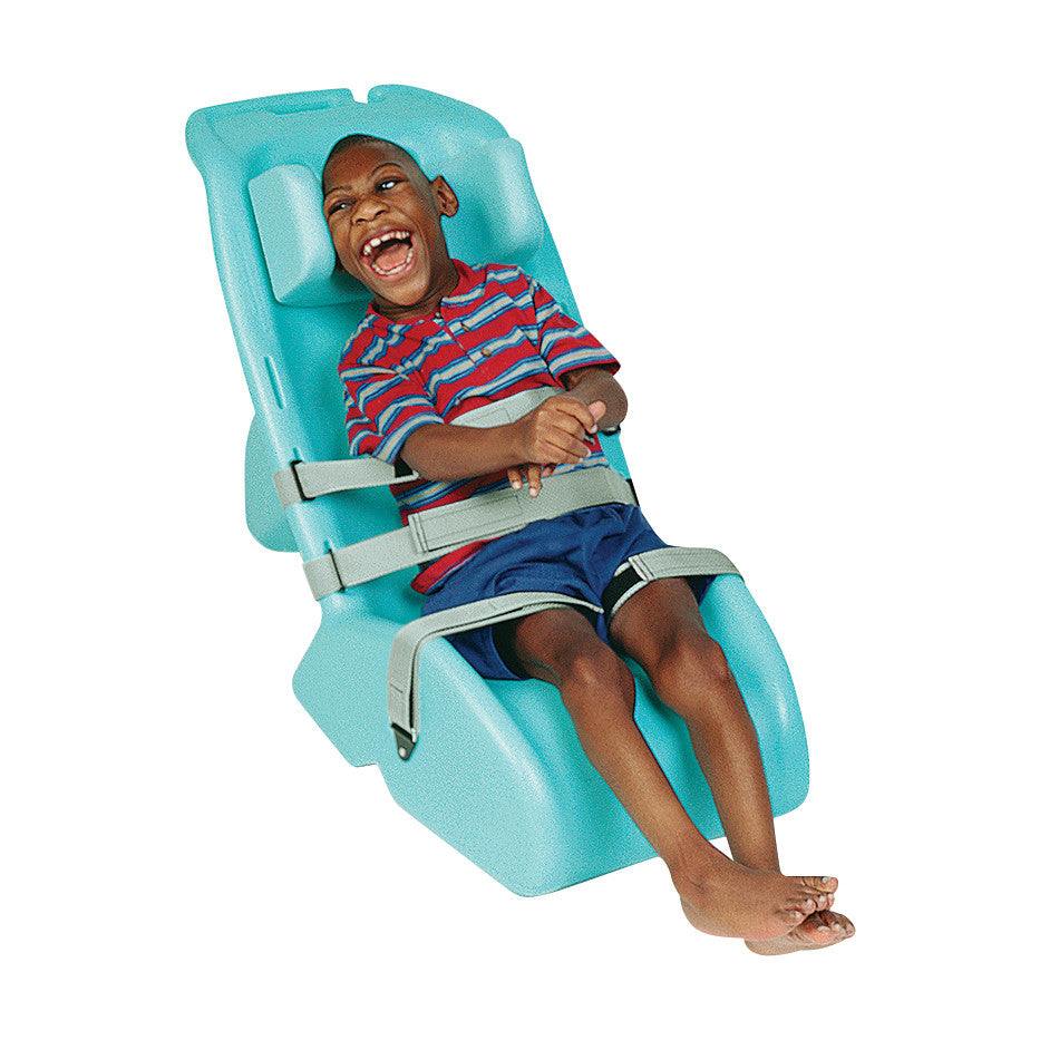 A child is sitting in a turquoise Children's Chaise, secured with safety straps, smiling and wearing a striped shirt and shorts.