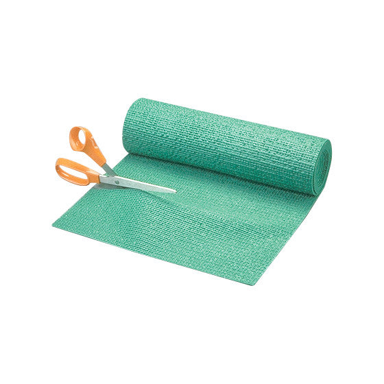 A roll of green Posey Grip non-slip material with orange-handled scissors partially cutting it.