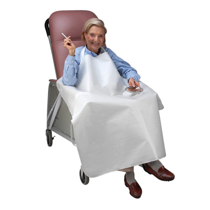 An elderly person in a wheelchair wears a SkiL-Care Wheelchair Smoker's Apron, holding a cigarette and ashtray.