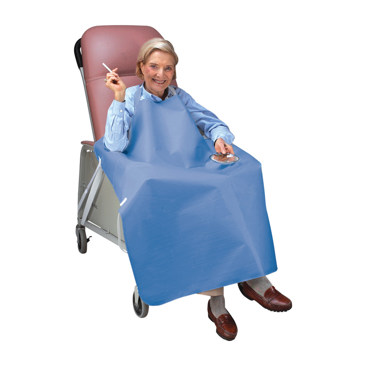 An elderly person sits in a chair wearing the SkiL-Care Geri-Chair Smoker's Apron, holding a cigarette above an ashtray.