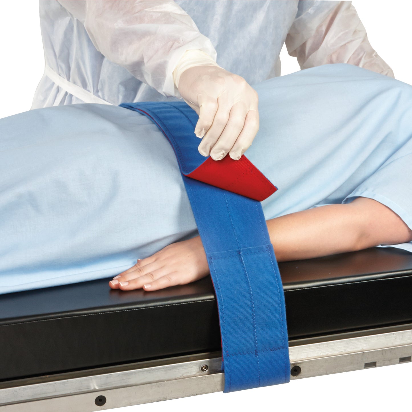 A person adjusts the AliMed Universal Strap, Two-Piece, Three Closures, Side Rail Hold, securing a patient on a medical table.