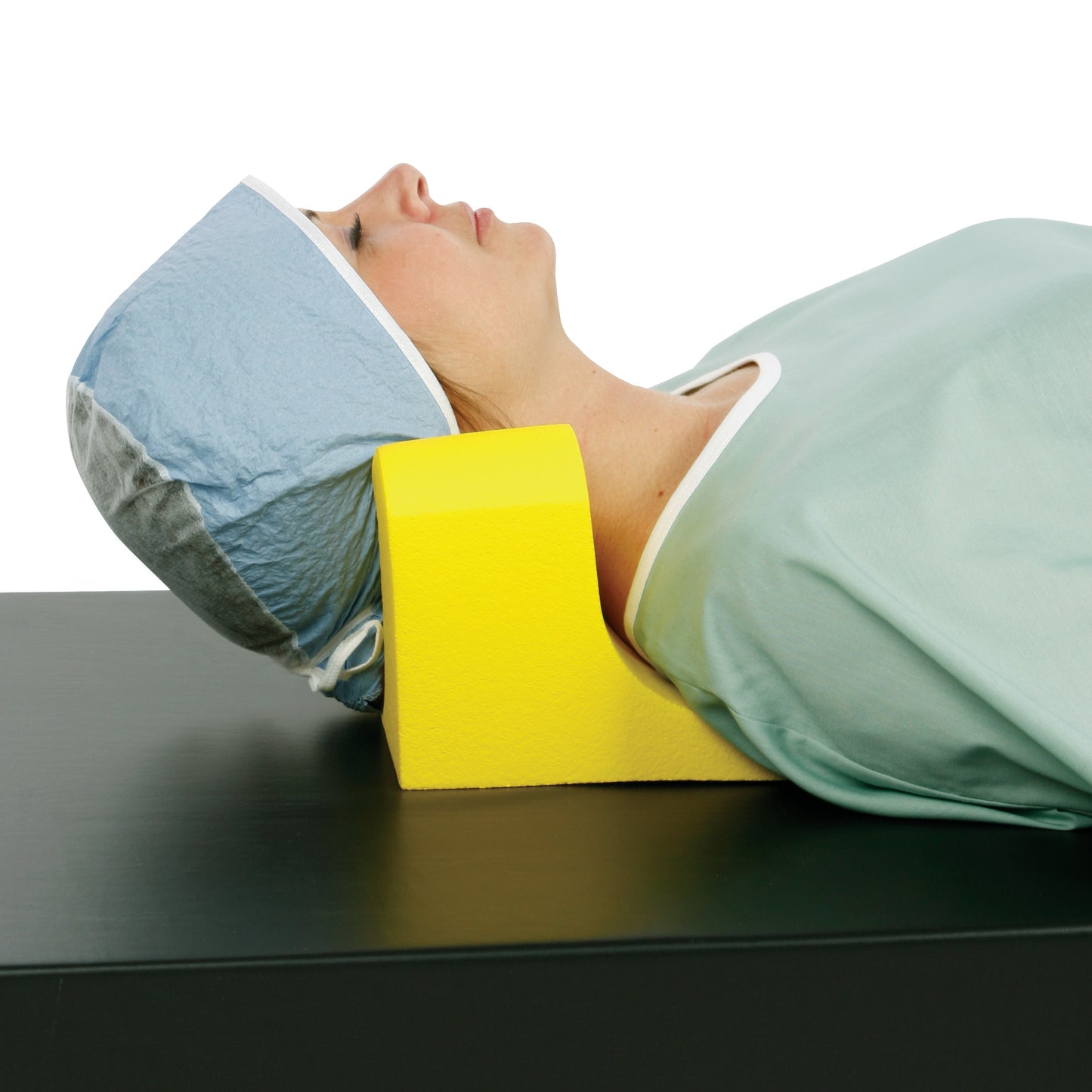 A person uses the AliMed Protecta-Coat Neck and Headrest, a yellow foam support, while lying on a black surface for comfort.