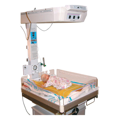 A baby lies on an AliMed AliGel Isolette Pad in a hospital infant warmer unit, wrapped in a patterned blanket.