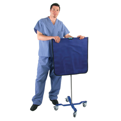 A person in scrubs stands next to the AliMed Rolling Radiation Shield, a blue panel on a wheeled stand for protection.
