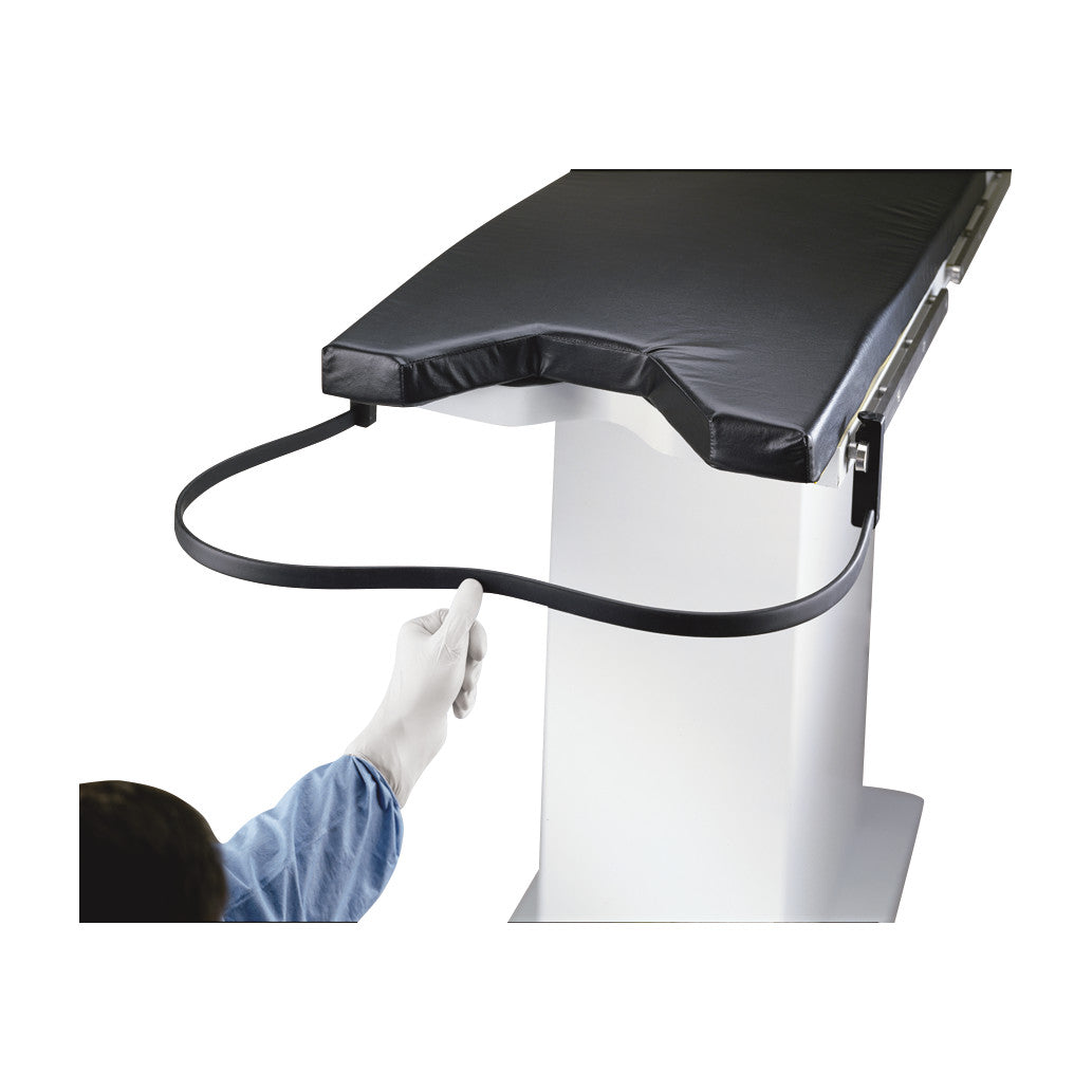 A gloved hand adjusts the Nonsterile Uro-Catcher Drape attached to a padded medical table, showing its flexible support.