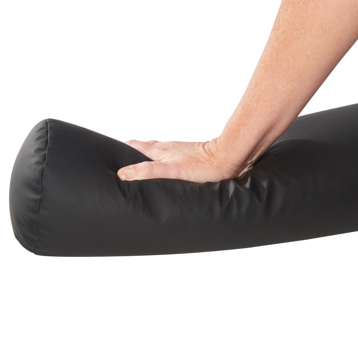 A hand presses down on a black AliMed ComPly Chest Roll Positioner, showing its flexibility and support.