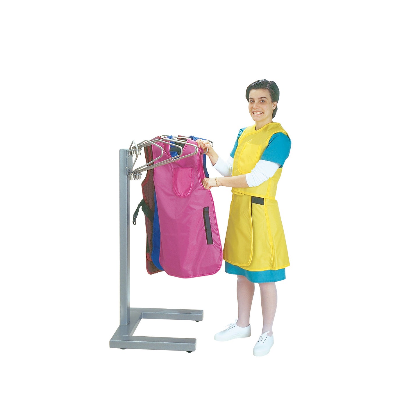 Person hanging aprons on an AliMed Mighty Max Apron Rack. The rack has a sturdy metal frame and holds multiple colorful aprons.