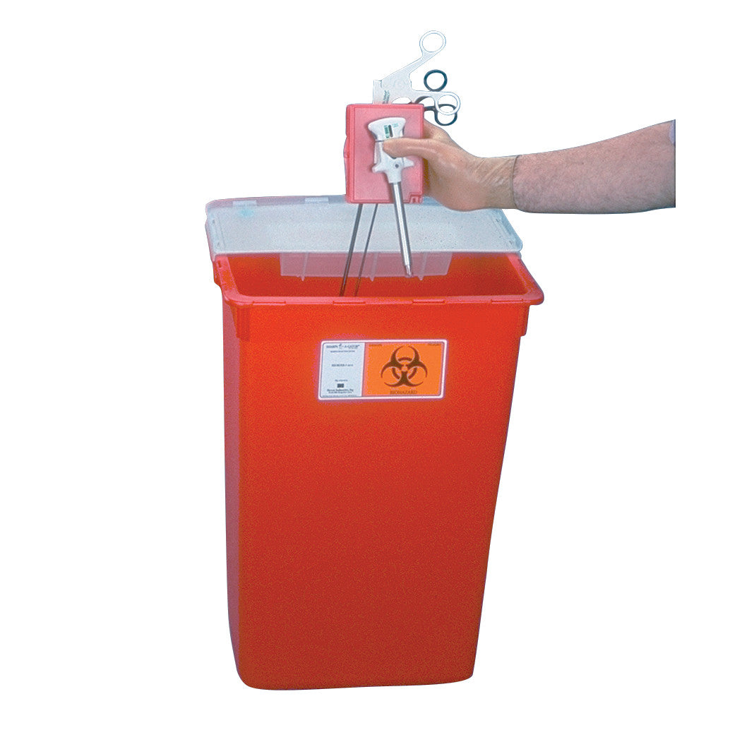 A hand disposes of medical tools into a Large Capacity Sharps Container, an orange bin with a biohazard symbol and clear lid.