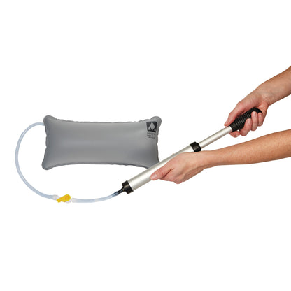 Hands hold a hand pump connected to the AliMed Adjustable Surgical Thyroid Positioner, a gray inflatable cushion.